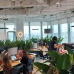 Employees in an open space full of green plants